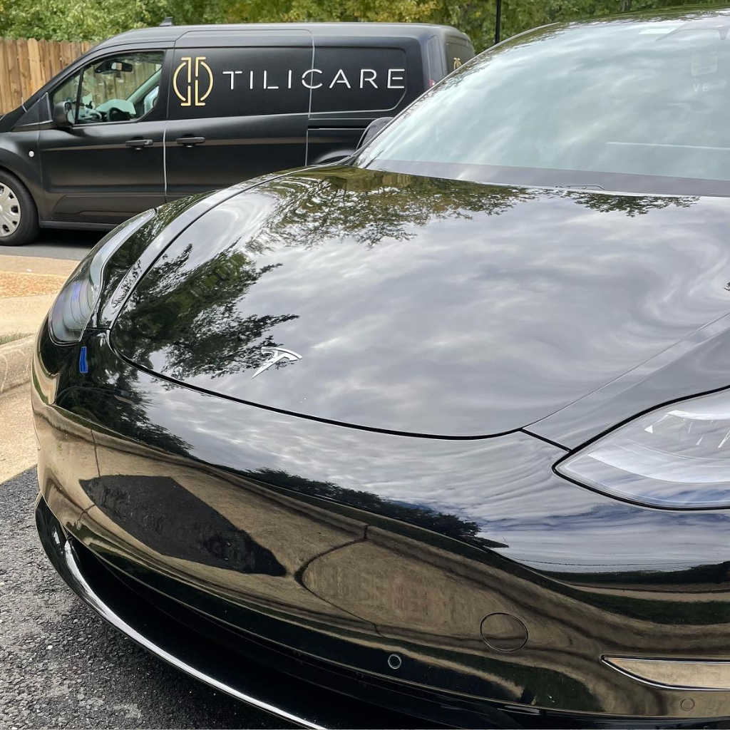 tesla model 3 with tilicare company at the back